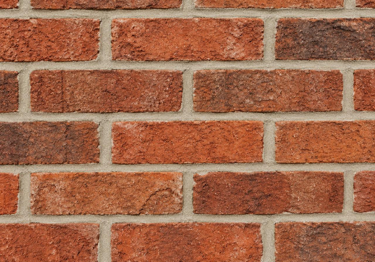 Exterior red brick wall with freshly repointed mortar joints